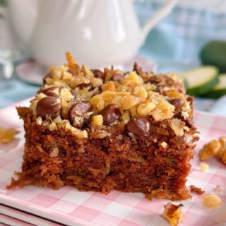 Chocolate Walnut Zucchini Cake cut into squares and served on a pink gingham plate.