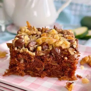 Chocolate Walnut Zucchini Cake cut into squares and served on a pink gingham plate.