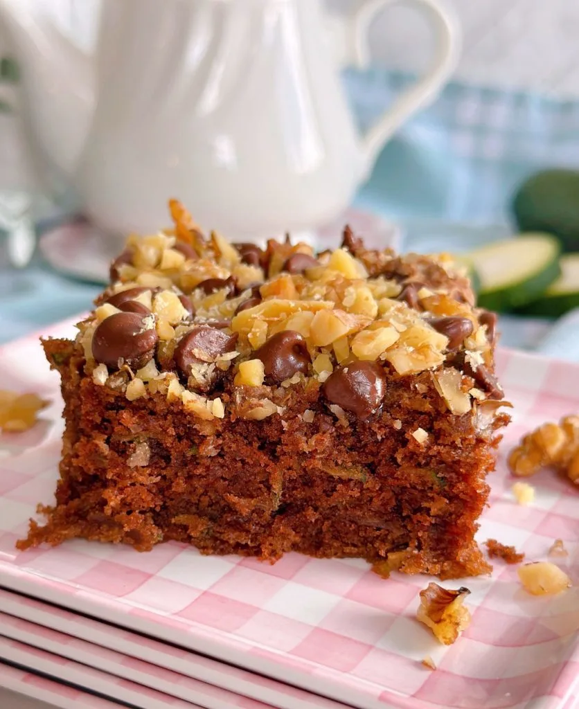 Chocolate Walnut Zucchini Cake cut into squares and served on a pink gingham plate.