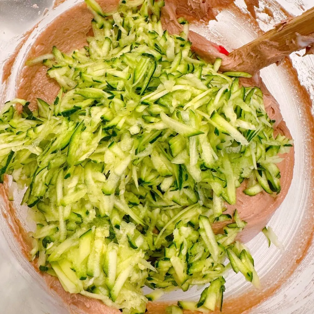 Adding squash to cake mix batter.