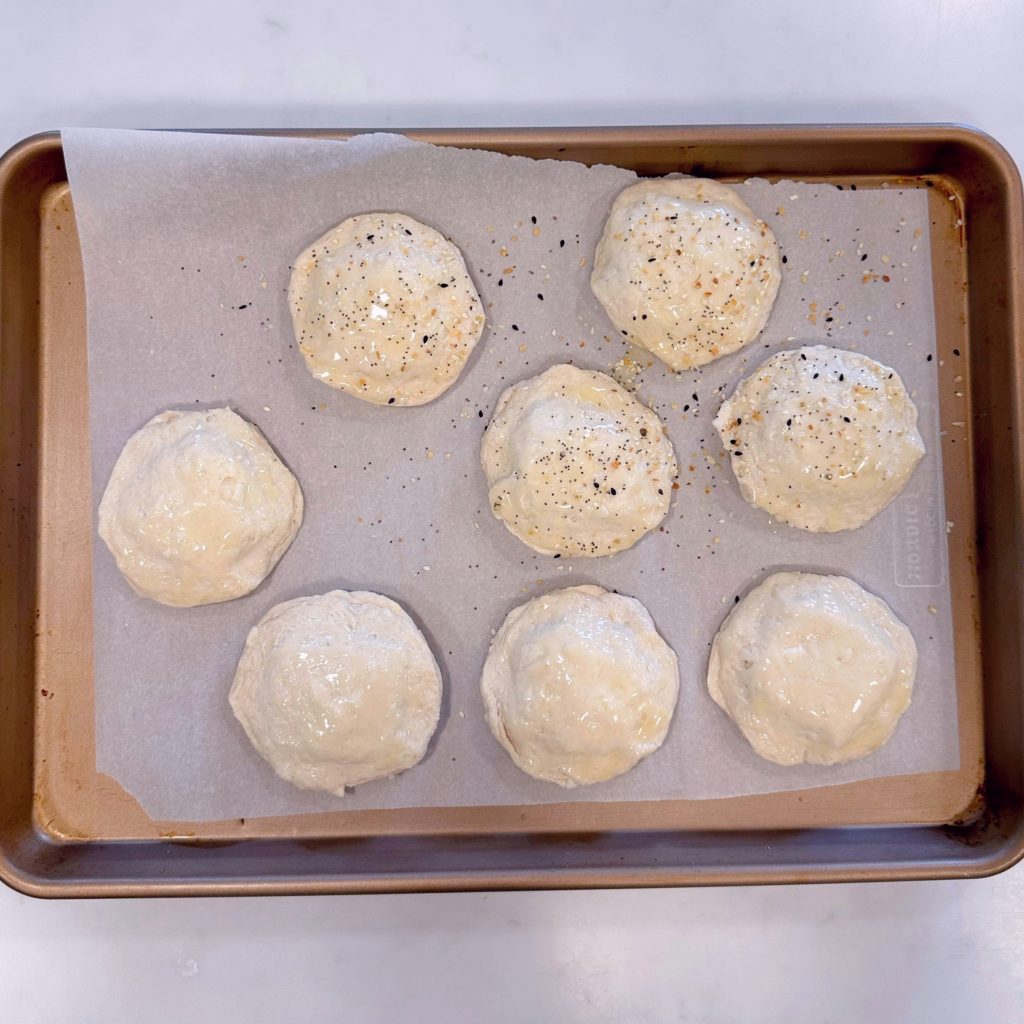 Biscuits brushed with butter and sprinkled with bagel seasoning.