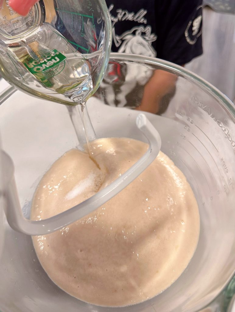 Adding salt and oil to yeast mixture.