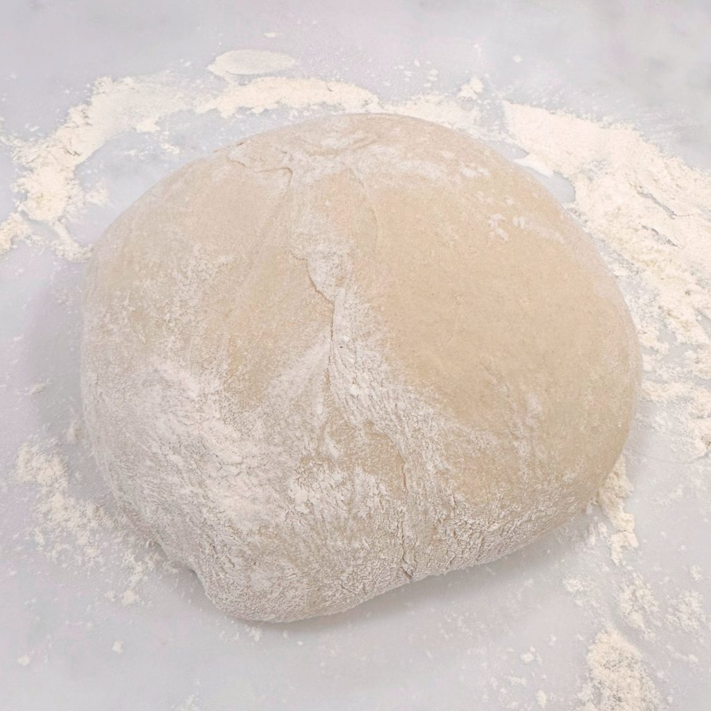 Kneading dough on a lightly floured surface and formed into a ball.