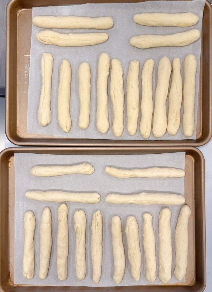 Breadsticks on parchment lined baking sheet.