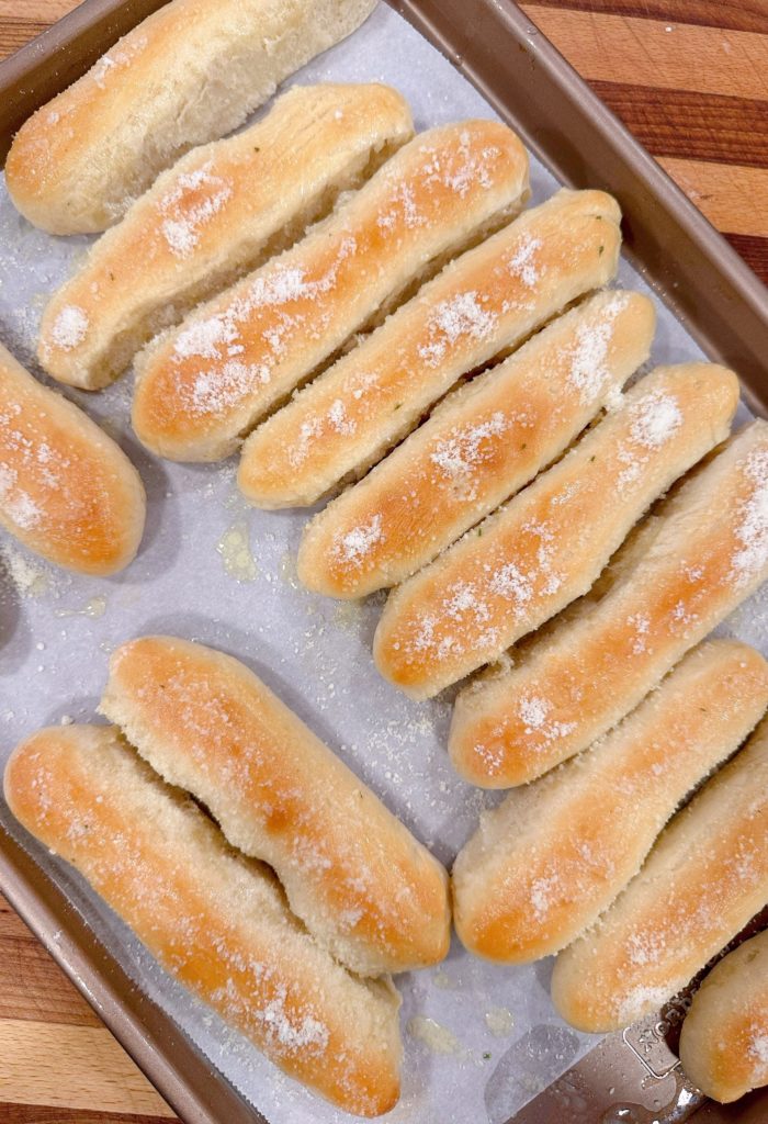 Breadsticks with Parmesan cheese sprinkled on top.