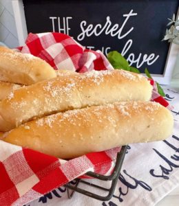 Easy Homemade Garlic Breadsticks in a basket with a red and white checked napkin.