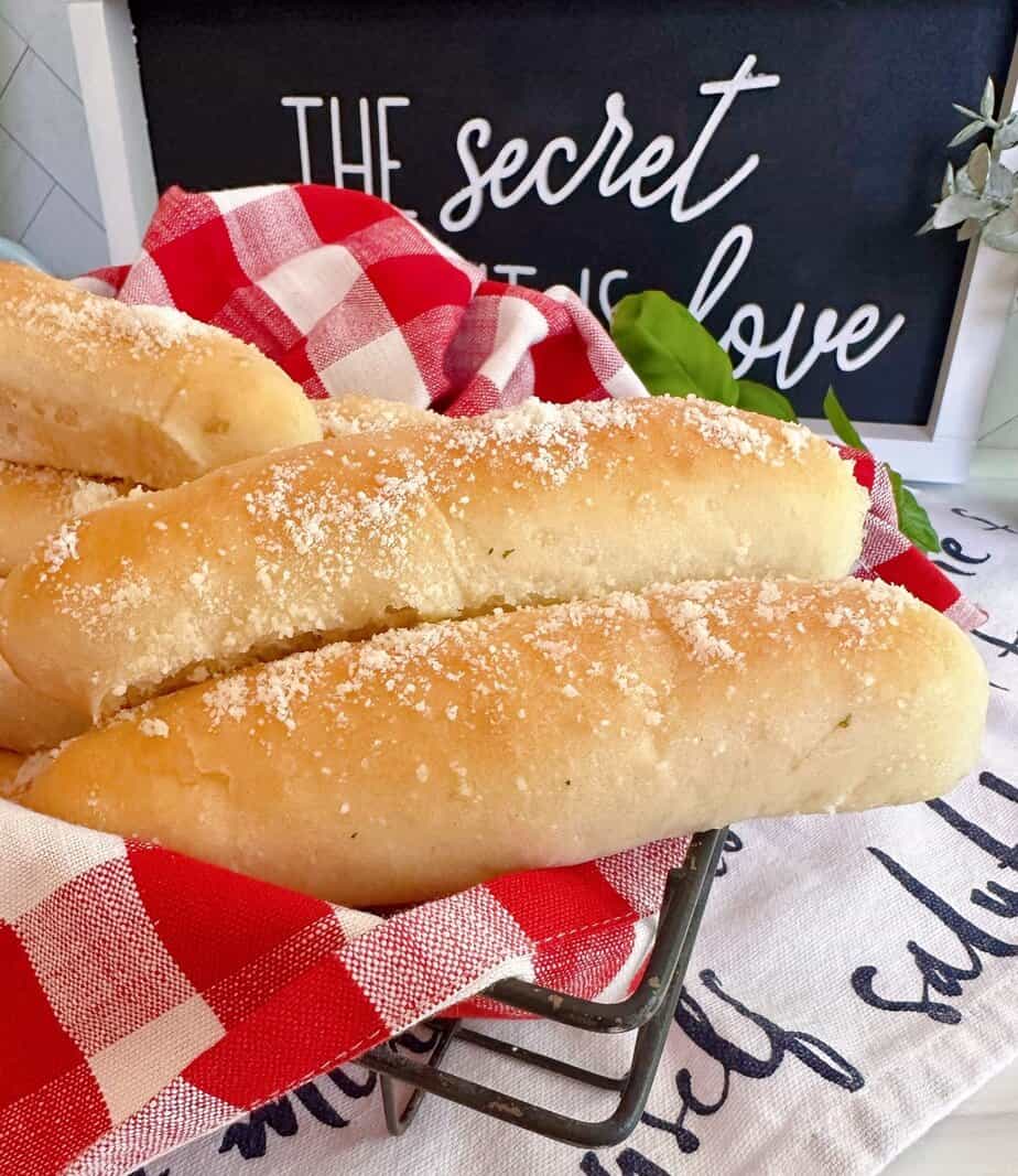 Easy Homemade Garlic Breadsticks in a basket with a red and white checked napkin.