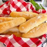 Basket full of breadsticks with garlic and parmesan cheese.