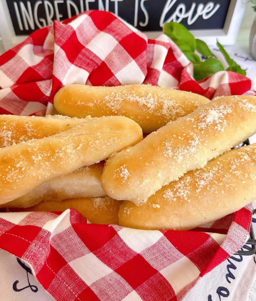 Basket full of breadsticks with garlic and parmesan cheese.