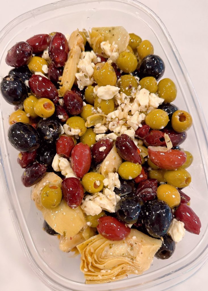 Olives in an airtight container to chill in the refrigerator.