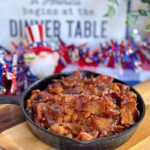 Oven baked beans in a small skillet with 4th of July decorations in the background.