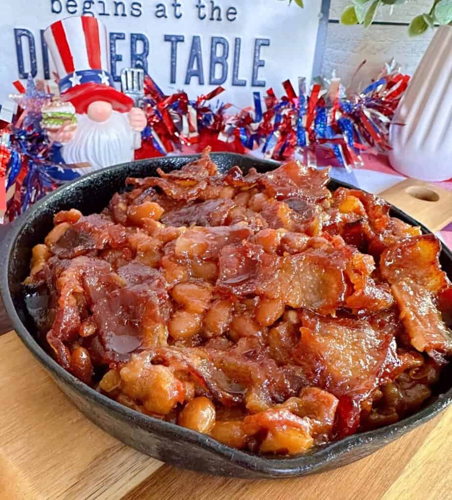 Baked Beans up-close in a small skillet on top of a cutting board.
