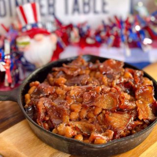 Oven baked beans up close with bacon on top.
