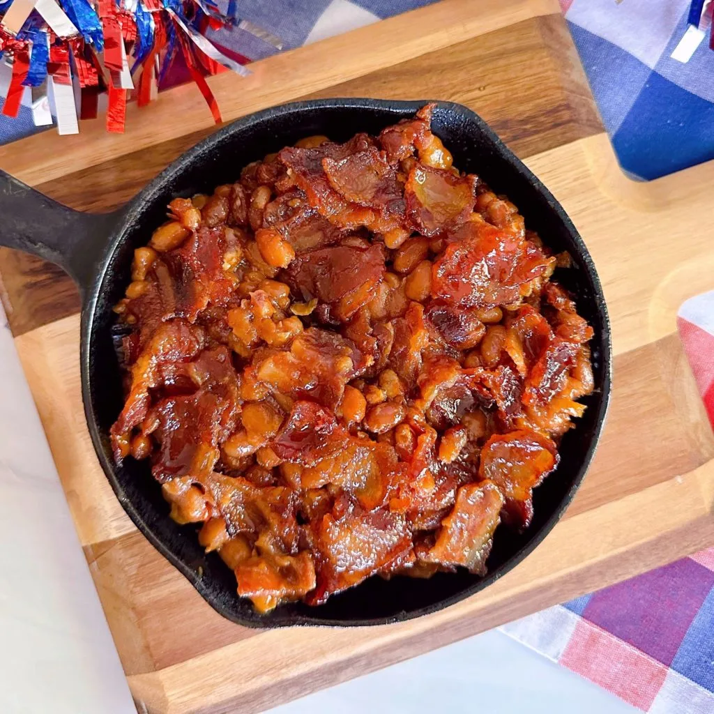 Oven Baked Beans over head shot looking down on the skillet full of baked beans and bacon.