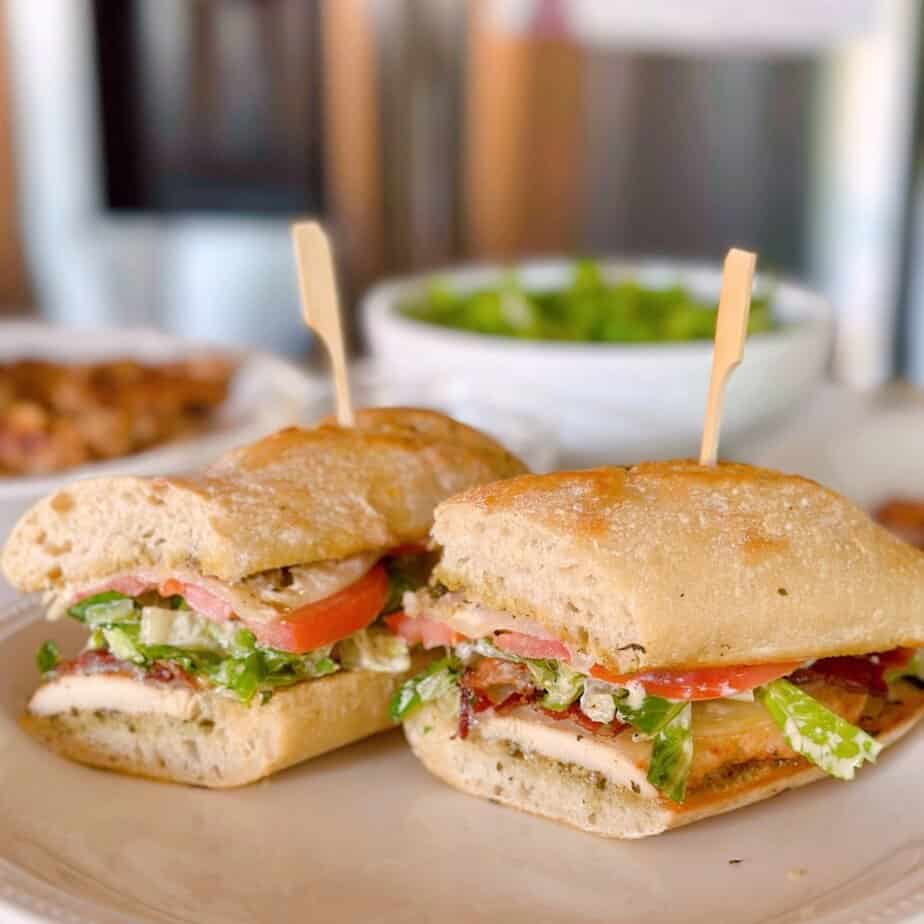 Chicken Caesar Sandwich cut in half on a plate.