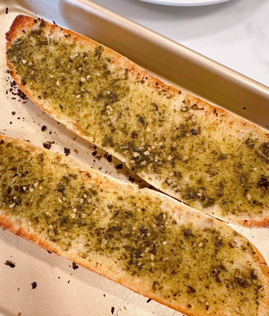 Toasted baguette with pesto sauce.