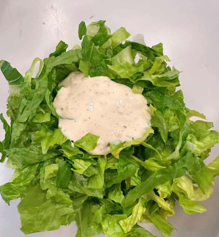 Lettuce with remaining caesar dressing for sandwich topping.