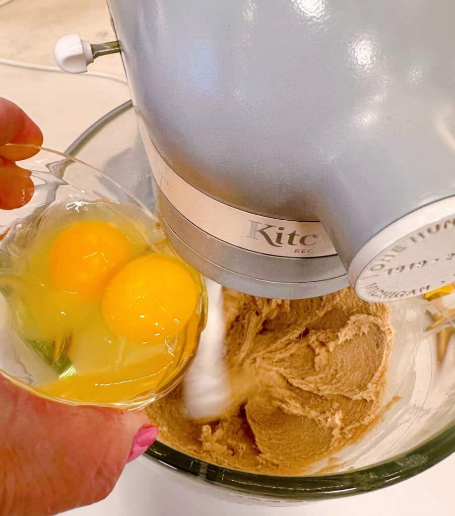 Adding the eggs to the sugars and butter mixture.