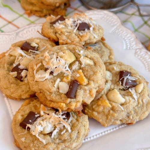 Stack of Coconut Mango Chocolate Chunk Cookies on a white plate.