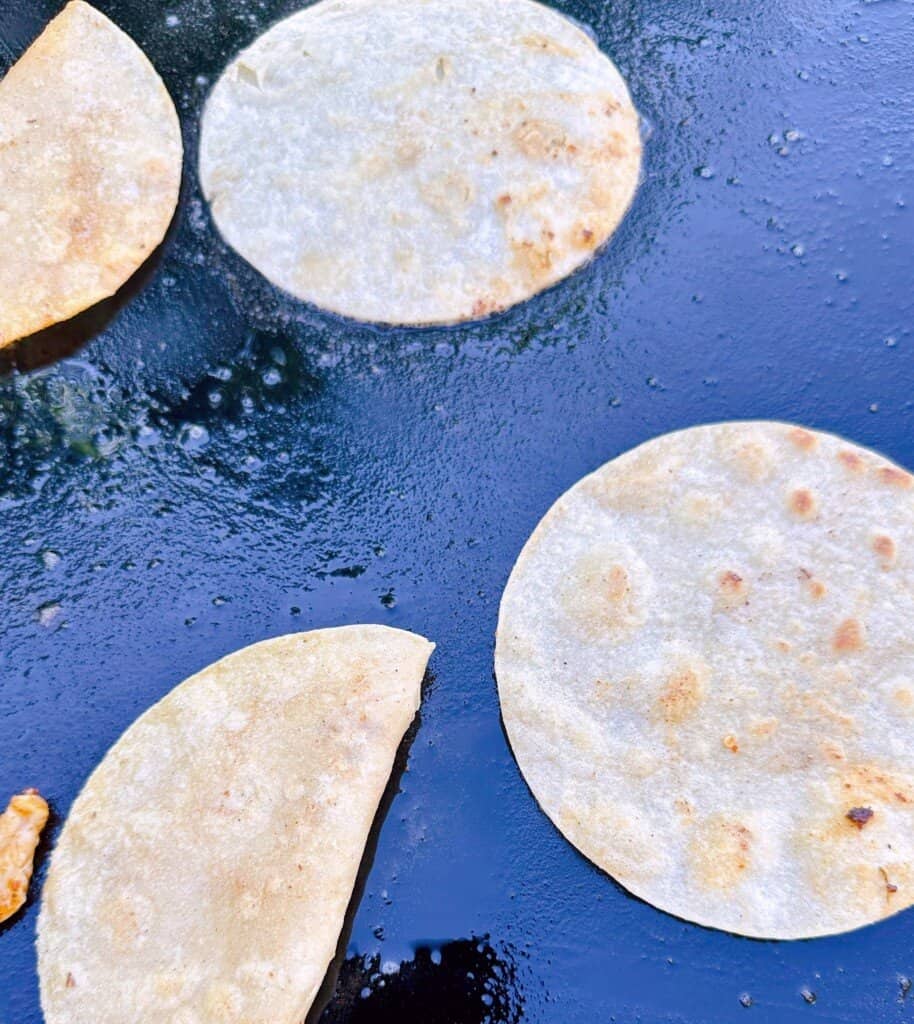 Cooking tortillas on the griddle.