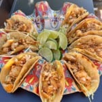 Tacos filled with cooked tilapia in a taco holder.