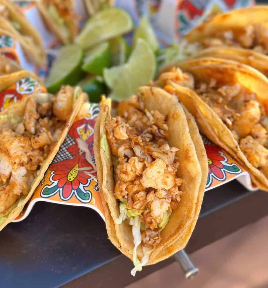 Fresh finished tilapia tacos with cabbage and fresh limes.
