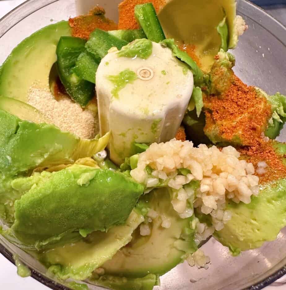 Ingredients for avocado crema in a small food processor.