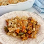Layered Beef and Potato Casserole served on a plate with the casserole in the background.