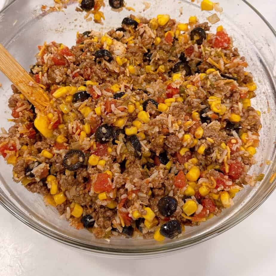Cheesy taco casserole ingredients mixed in a bowl.