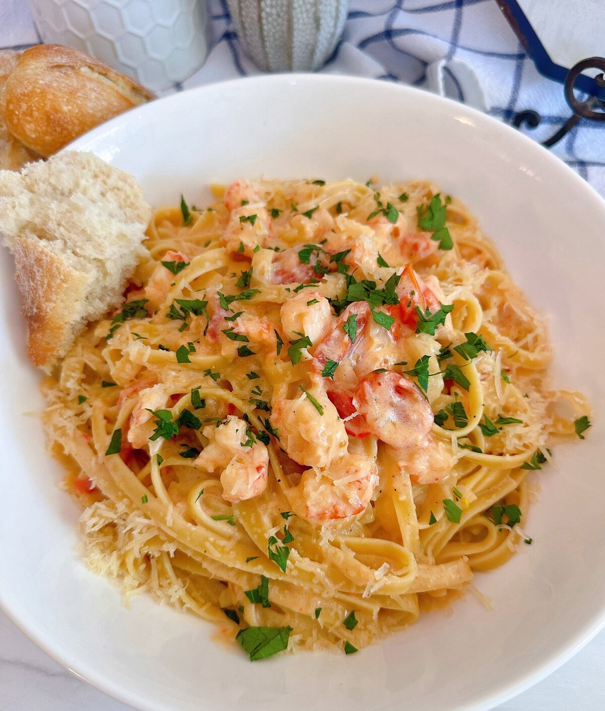 Lobster Bisque on a bed of noodles with a piece of crusty bread.
