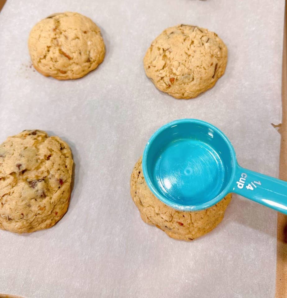 Making a well in the center of the cookies using a small measuring cup.