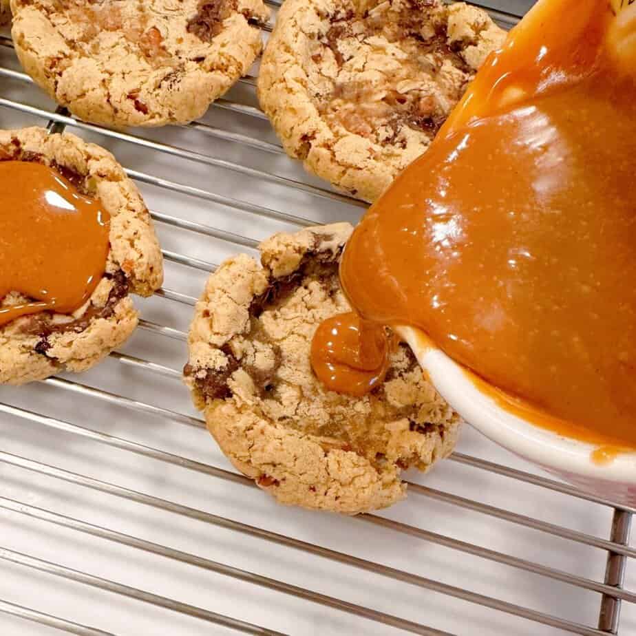 Pouring caramel into the center of each cookie.