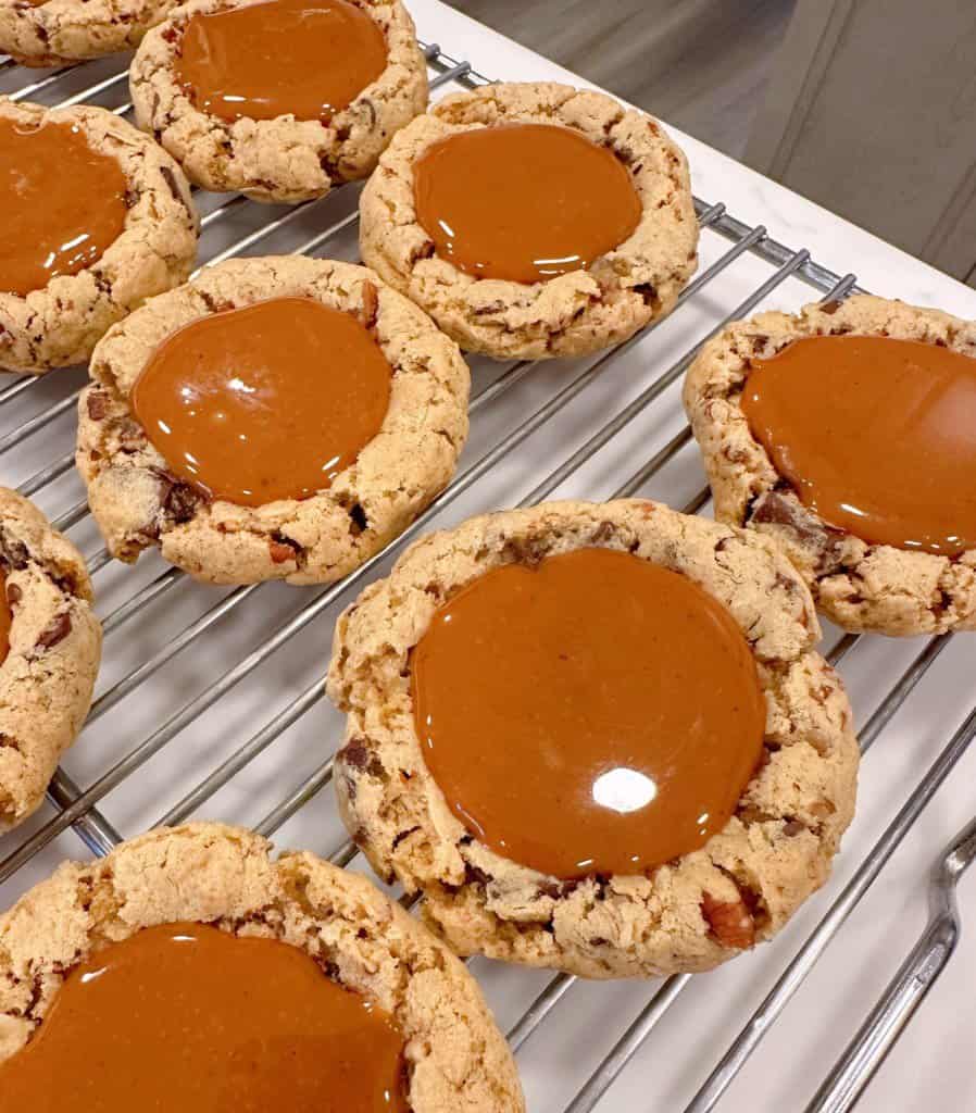Carmelita cookies on a cooling rack with caramel centers.