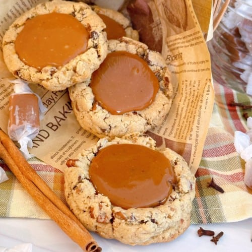 Carmalita Cookies on a paper with cinnamon sticks.