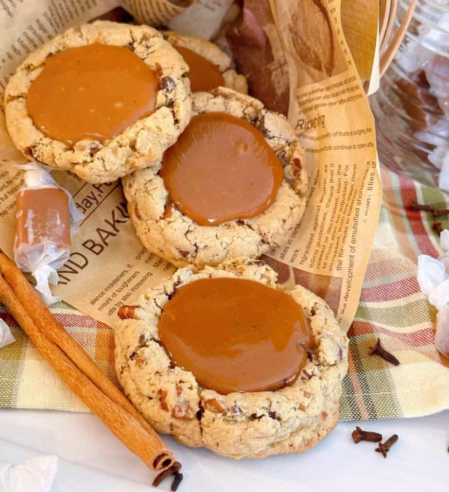 Carmalita Cookies on a paper with cinnamon sticks.