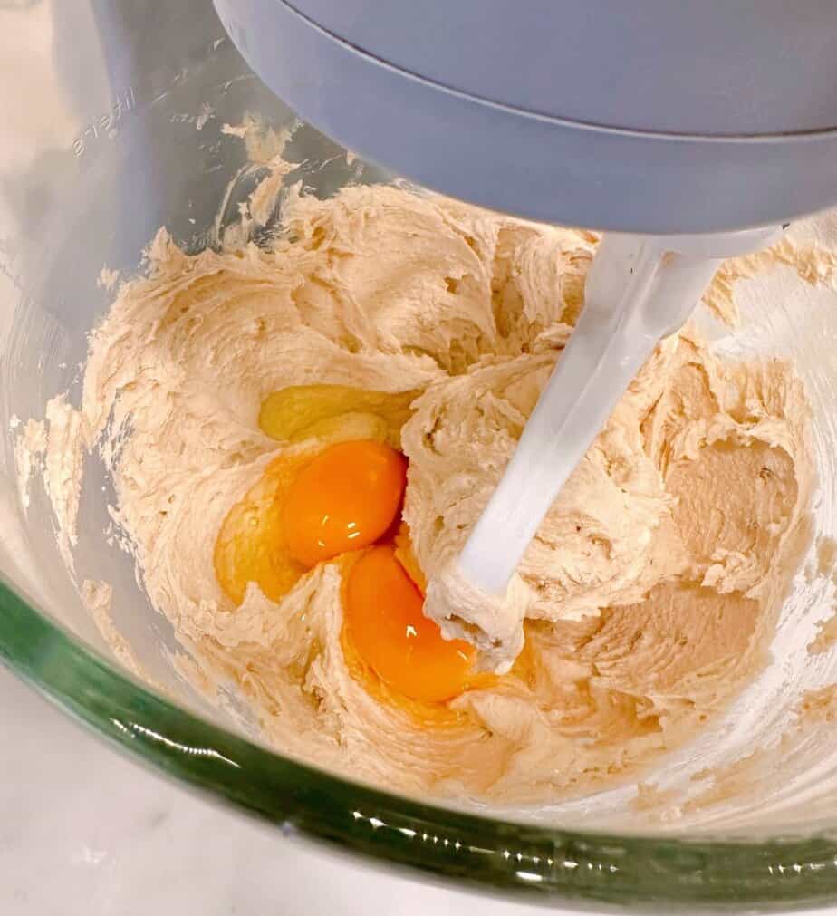 Adding Eggs one at a time until combined with sugar and butter.