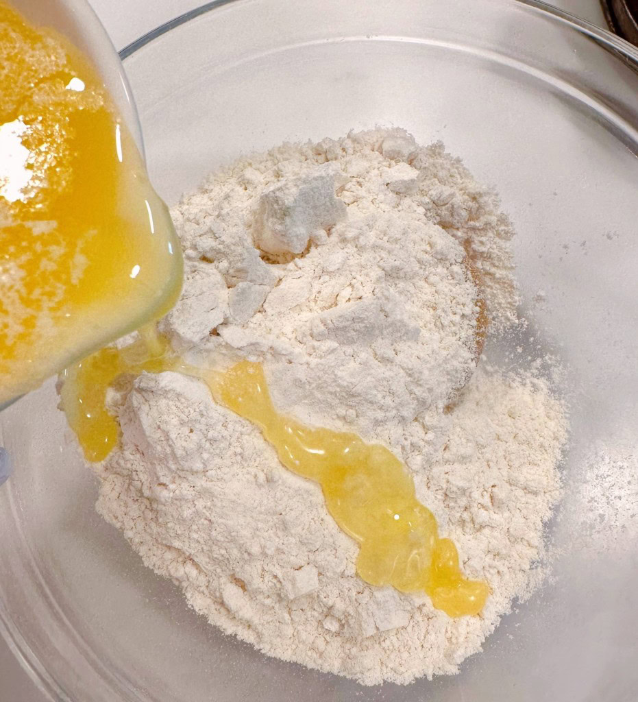 Adding melted butter to crumb topping ingredients.