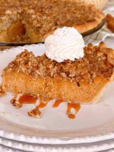 Slice of Sweet Potato Pie on a serving dish with caramel sauce.