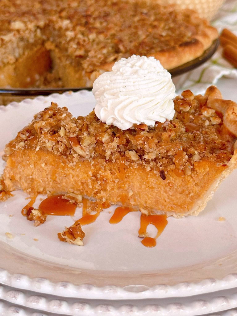 Slice of Sweet Potato Pie on a serving dish with caramel sauce.
