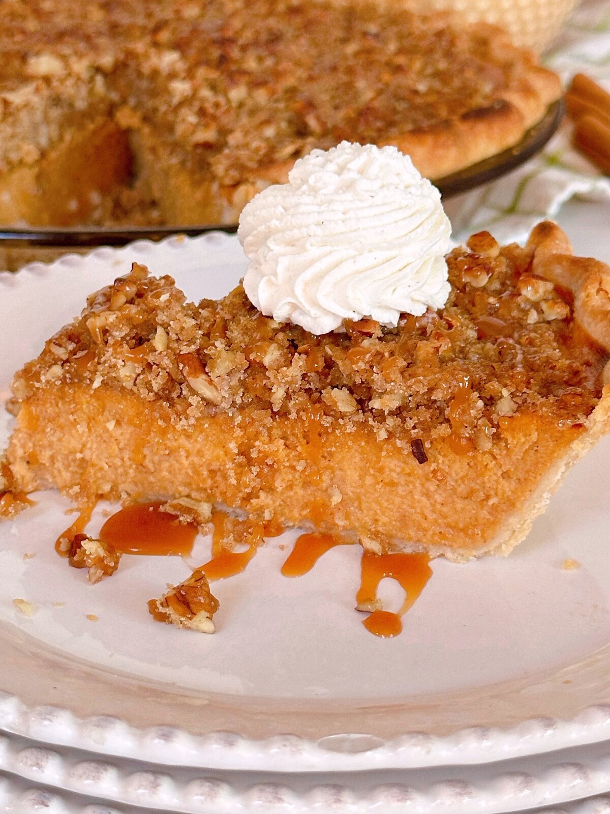 Slice of Sweet Potato Pie on a serving dish with caramel sauce.