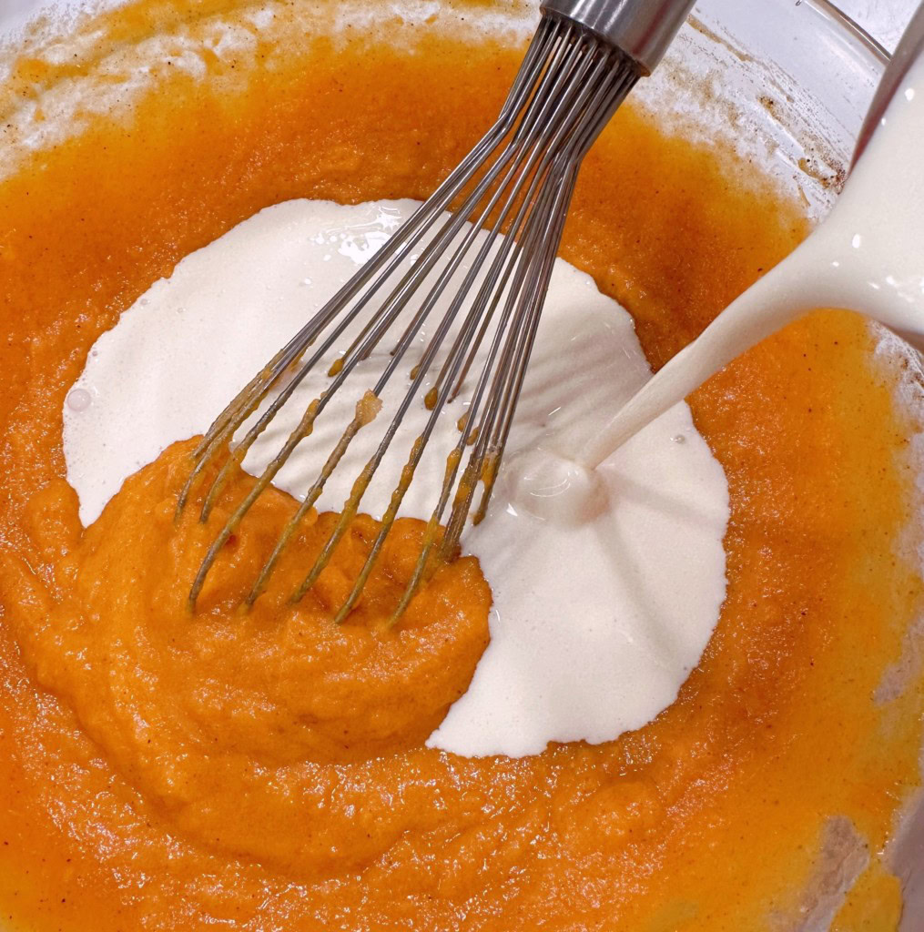 Adding cream to sweet potato filling.