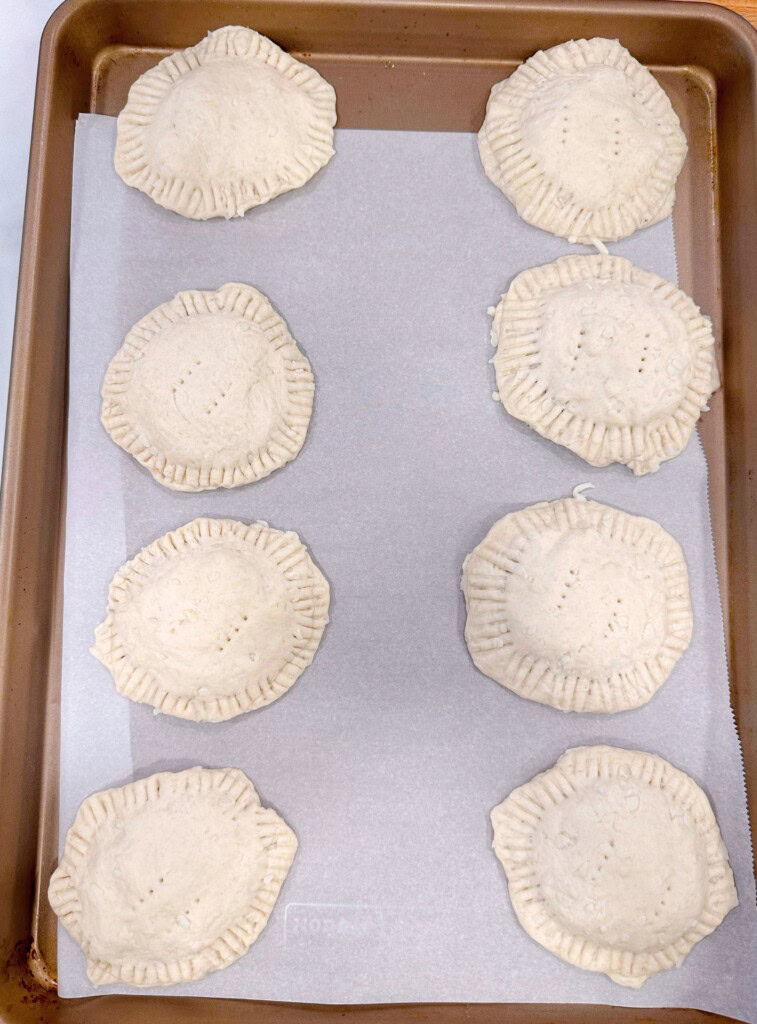 Place the top of each biscuit on top of the toppings and crimp each edge.