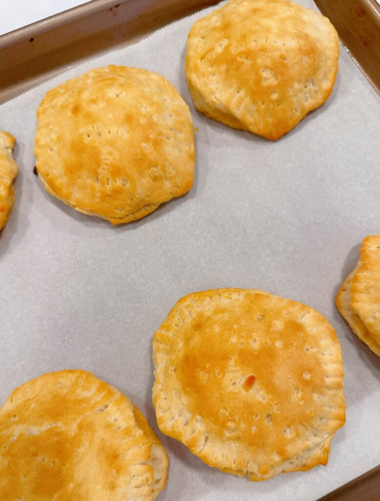 Baked pizza biscuits on a cookie sheet.