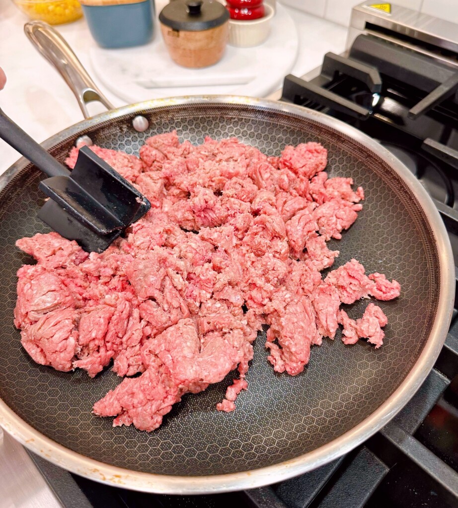 Cooking Ground Beef in large skillet on the stove top.