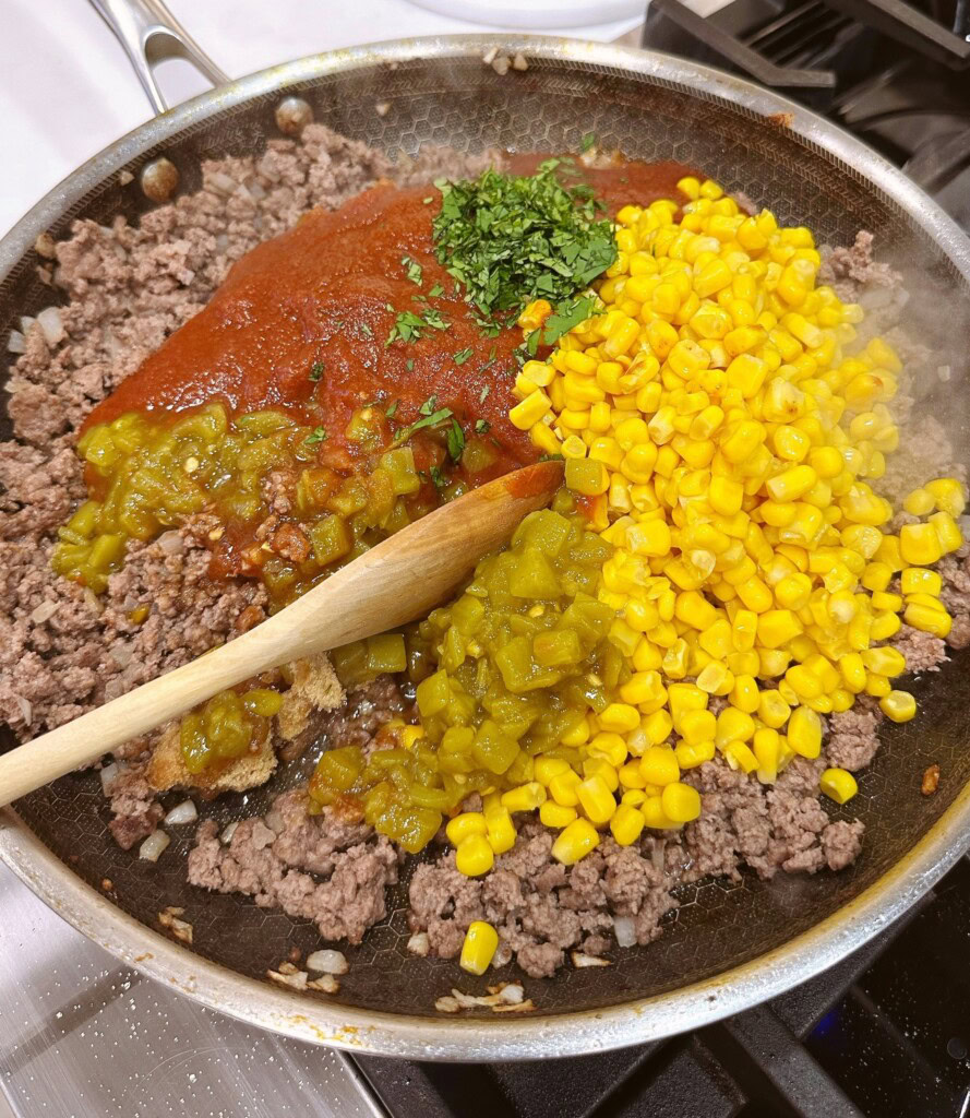 Adding remaining ingredients to the sloppy joe pie.