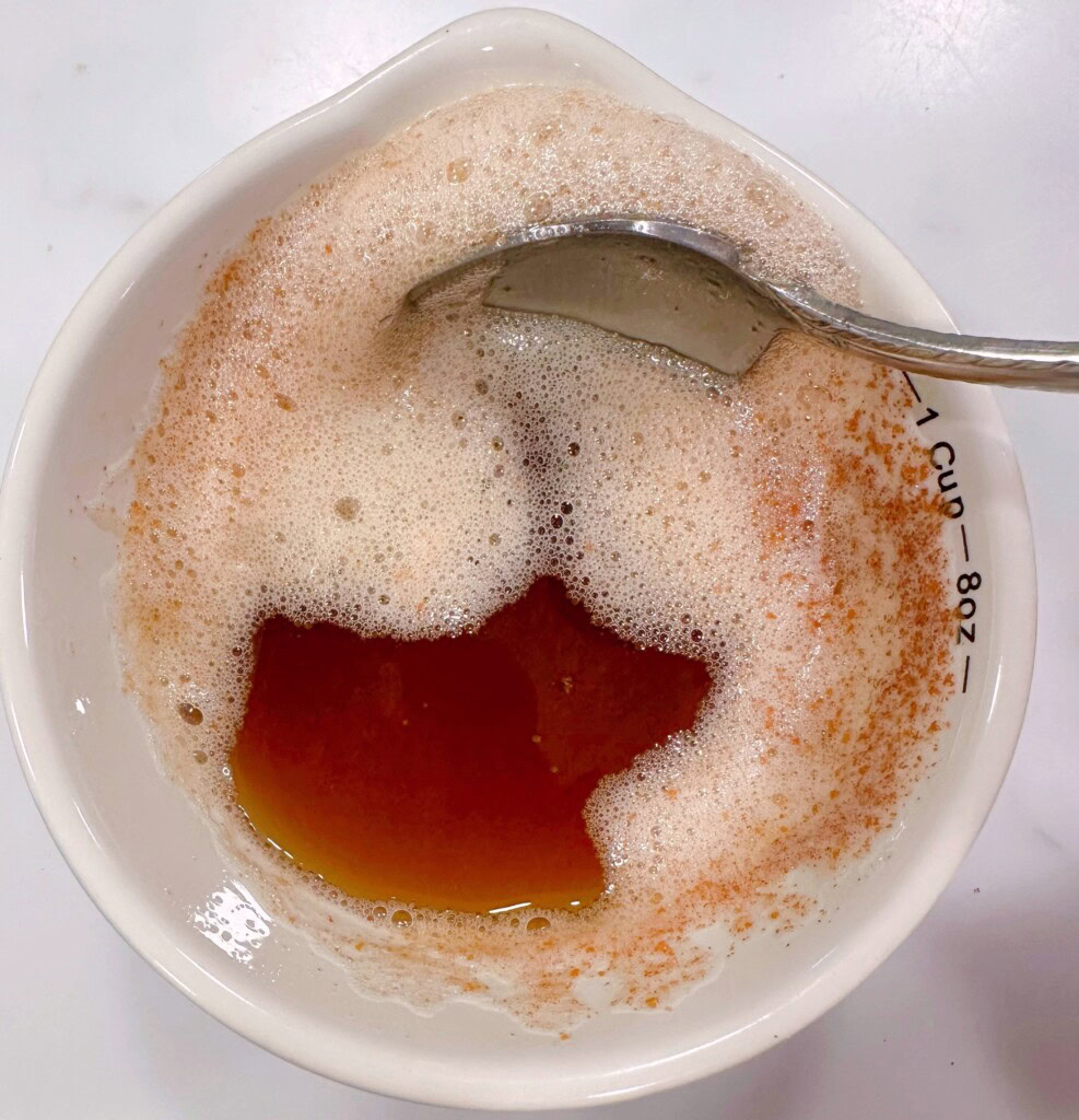 Brown butter with foam in a small bowl cooling.