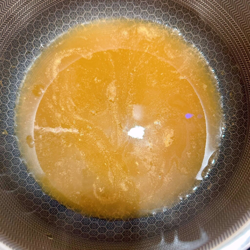 Apple cider in a pan reducing over low heat.