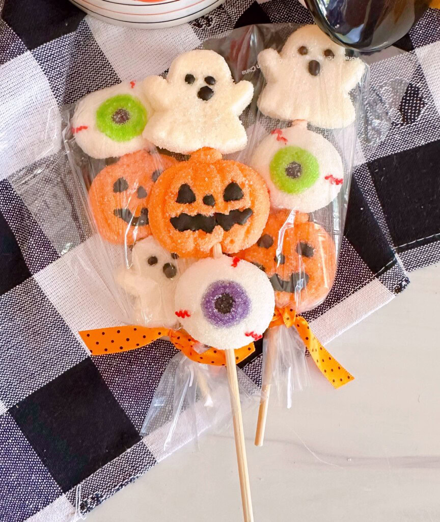 Halloween Marshmallow Pops on a black and white checked cloth.