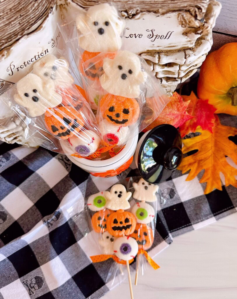 Overhead shot of Halloween Marshmallow Pops in a jar and on the table.