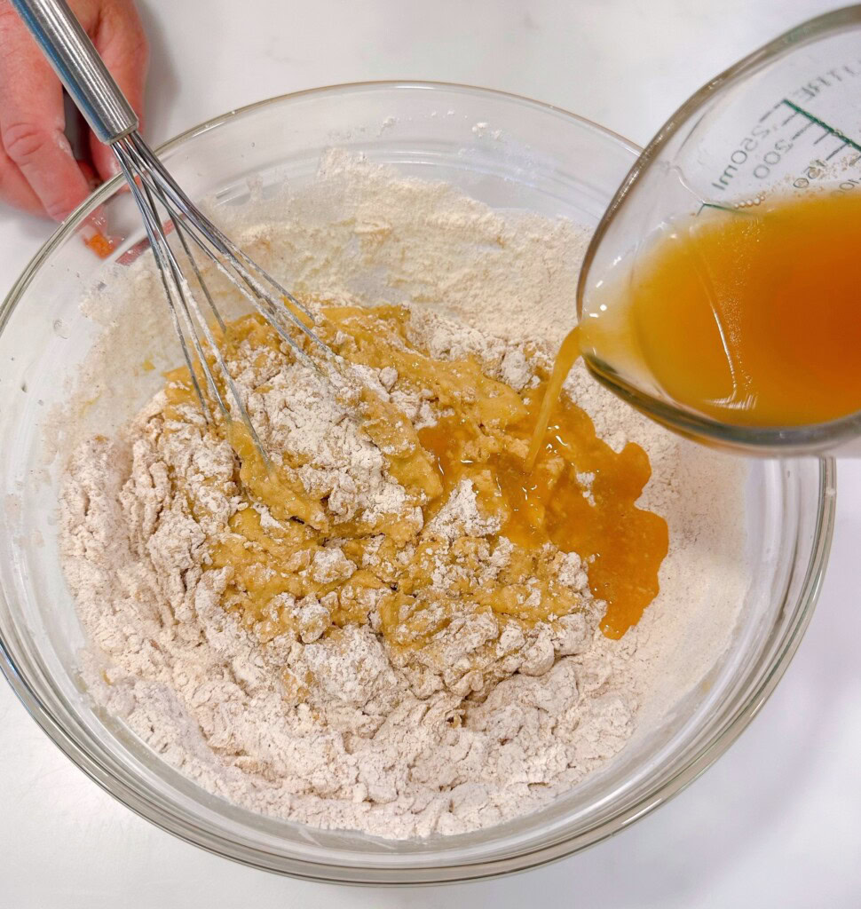 Adding apple cider to cake batter.